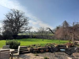 a garden with chairs and a table and a lawn at Little Underhill in Oswestry