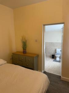 a bedroom with a bed and a bathroom with a toilet at Babo Bolton room en suite in Farnworth