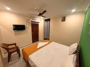 a bedroom with a bed and a ceiling fan at Capital Stay Inn in Vijayawāda
