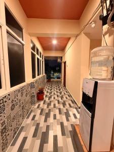 a hallway with a checkered floor in a house at Capital Stay Inn in Vijayawāda