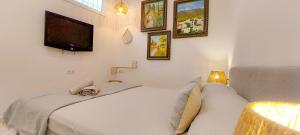 a bedroom with two beds and a flat screen tv at VelenaRubia in Vélez-Málaga
