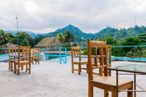 a row of chairs sitting next to a swimming pool at Habitación Confort Queen in Peña Blanca