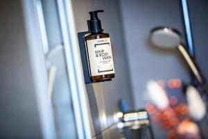 a bottle of moisturizing soap hanging on a wall at Bude54 in Sankt Peter-Ording +56 photos