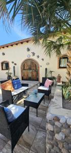 a patio with chairs and tables and a building at Rancho Espinoza La Casita in San Ignacio