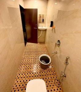 a small bathroom with a toilet and a sink at Capital Stay Inn in Vijayawāda