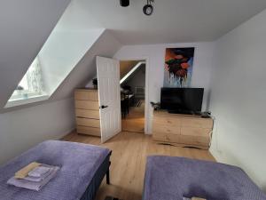 a room with a bed and a television and a staircase at Cute apartment close to highway in Edmundston