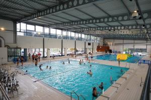 a large swimming pool with many people in it at Jungle Évasion, Épernay - Jacuzzi & Sauna in Épernay