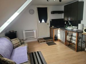a living room with a couch and a kitchen at Cute apartment close to highway in Edmundston +4 photos