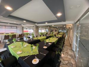 a row of tables in a restaurant with green table settings at Hotel Nicolás Temuco in Temuco