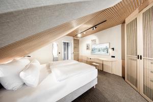 a bedroom with a large white bed and a desk at Bude54 in Sankt Peter-Ording