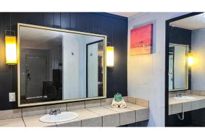 a bathroom with two sinks and a large mirror at Studio 6 Suites Albany, GA in Albany