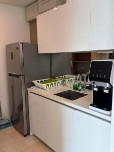 a kitchen with a sink and a refrigerator at vortex luxury APATMENT BY FRINDSHIP in Kuala Lumpur