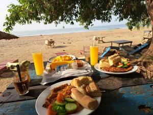 a table with plates of food on the beach at Happy Corner Beach Garden in How Ba +15 photos