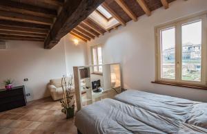 a bedroom with a bed and a couch and windows at B&B Le Grazie in Parma