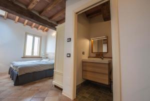 a bedroom with a bed and a mirror and a sink at B&B Le Grazie in Parma