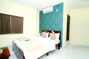 a bedroom with two beds and a blue wall at Sri Sai comforts - Bannerghatta Main Road in Bangalore
