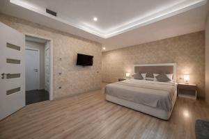 a bedroom with a bed and a tv on the wall at Diplomat Suites Hotel in Baku +55 photos