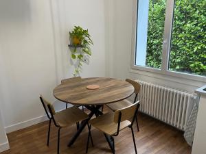 a wooden table and chairs in a room with a window at Au Vingt Neuf in Loches