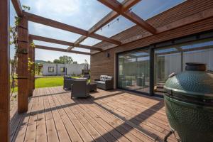 a patio with a wooden deck with a large glass door at Rezidence Strachotín in Strachotín