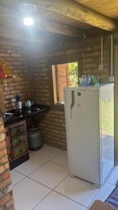 a kitchen with a refrigerator and a stove at Recanto Nativos in Garopaba