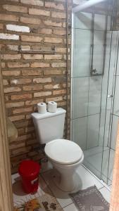 a bathroom with a toilet and a glass shower at Recanto Nativos in Garopaba +24 photos