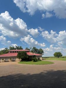 a building with a tree in front of it at Water on Waldrift Guesthouse in Vereeniging