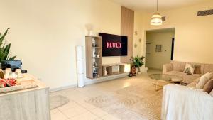 a living room with a couch and a tv at Spacious 2BR Apartment,3 Bathrooms, Near Mall in Abu Dhabi