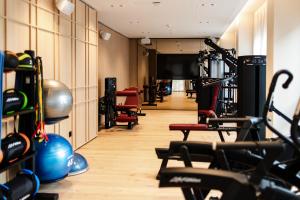 a gym with a bunch of equipment in a room at Hôtel des Innovations - Hôtel & Appartements - Votre séjour entre Fribourg, ville médiévale et La Gruyère et ses Bains in Marly-le-Grand