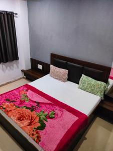 a bedroom with a bed with a red and pink blanket at Hotel Neelkanth in Vrindāvan