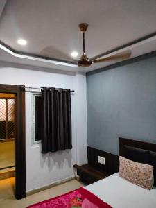 a room with a bed and a ceiling fan at Hotel Neelkanth in Vrindāvan +4 photos