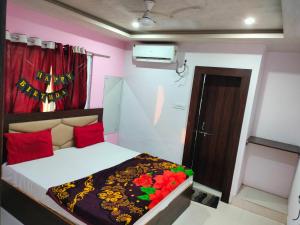 a bedroom with a bed with red pillows and a door at Hotel Neelkanth in Vrindāvan