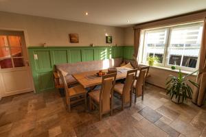 a dining room with a wooden table and chairs at Rosenberghof in Hillesheim