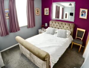 ein Schlafzimmer mit einem weißen Bett und einem Spiegel in der Unterkunft O'Gradys Hotel in Redcar