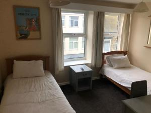 ein Hotelzimmer mit zwei Betten und zwei Fenstern in der Unterkunft O'Gradys Hotel in Redcar + 4 Fotos