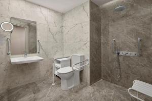 ein Badezimmer mit Toilette, Waschbecken und Dusche in der Unterkunft Concorde Tower Hotel & Casino in Lefkosa Turk