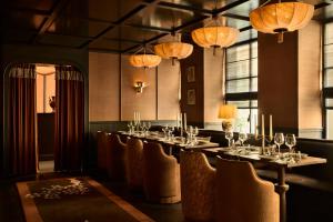 a dining room with a long table with chairs and lights at L'Opale Noire in Paris +31 photos