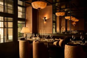 a dining room with tables and chairs and a mirror at L'Opale Noire in Paris