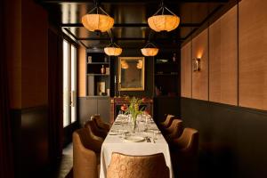 a dining room with a table and chairs and lights at L'Opale Noire in Paris