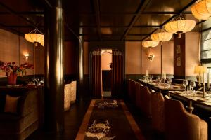 a dining room with a long table and chairs at L'Opale Noire in Paris