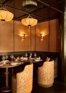 a dining room with two tables and chairs and lights at L'Opale Noire in Paris