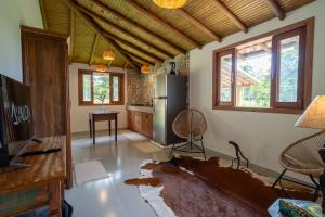 a living room with a refrigerator and a table at Casa Xibas e Loft Trancoso in Trancoso