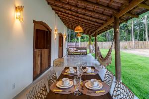 a dining room with a table and chairs on a patio at Casa Xibas e Loft Trancoso in Trancoso