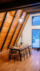 a large room with a long table with chairs at Peaceful Cabin in Lunca Bradului