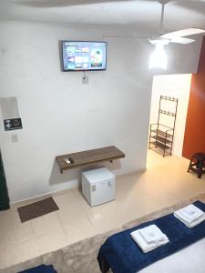 ein Raum mit einer Bank und einem Fernseher an der Wand in der Unterkunft Suíte Aconchegante na Natureza - RepousaAquiÓ in Olímpia