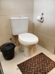ein Badezimmer mit weißer Toilette und Teppich in der Unterkunft Suíte Aconchegante na Natureza - RepousaAquiÓ in Olímpia