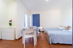 a bedroom with two beds and a table and chairs at Residence Emmesse in Zambrone