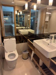 a bathroom with a toilet and two sinks and a mirror at Harbour Nest in Hong Kong