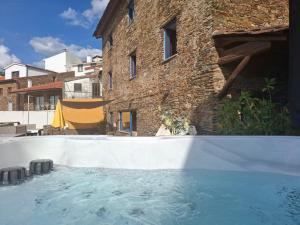 a swimming pool in front of a brick building at Campus Natura in Arganil