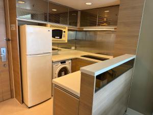 a kitchen with a refrigerator and a washer and dryer at Harbour Nest in Hong Kong +3 photos