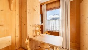 a wooden table in a room with a window at Locanda Montana in San Vito di Cadore +42 photos